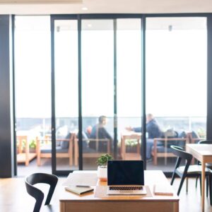 Table with notebook and laptop inside rooftop cafe